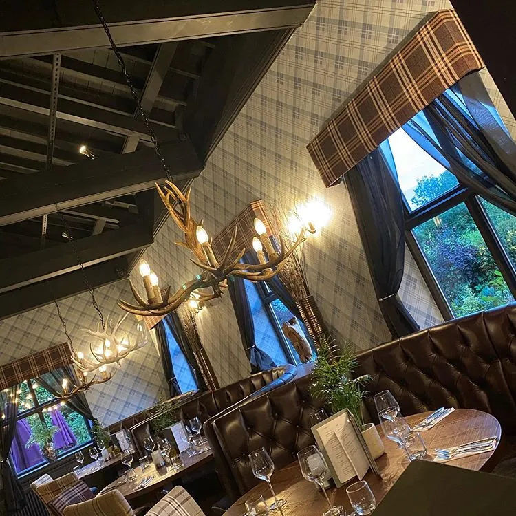 The dining room, with leather booths under antler chandeliers