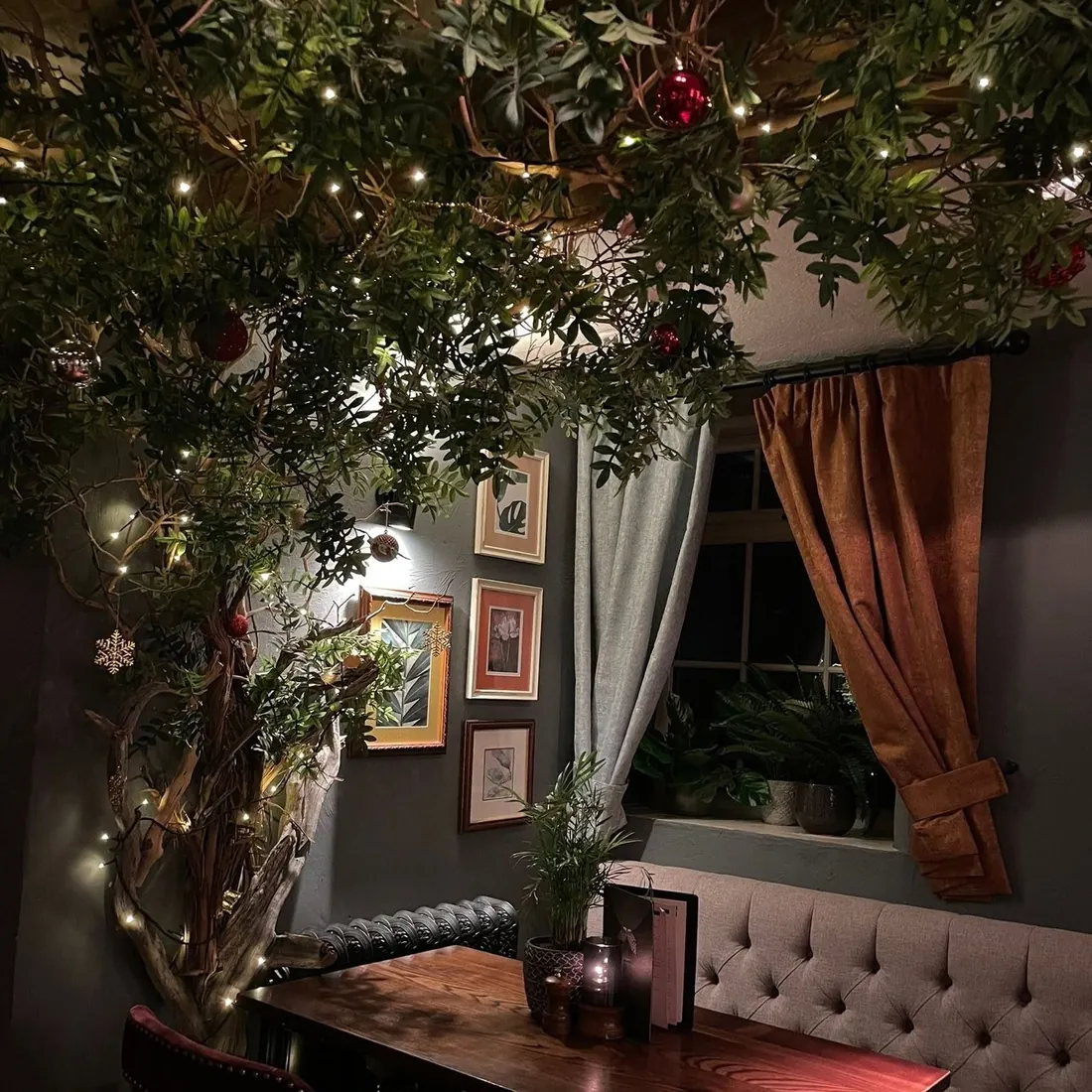 A booth under the tree, dressed with fairy lights and baubles for Christmas