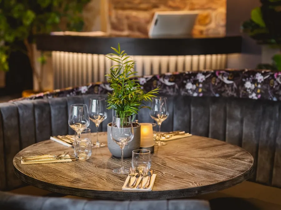 A round booth laid for dinner