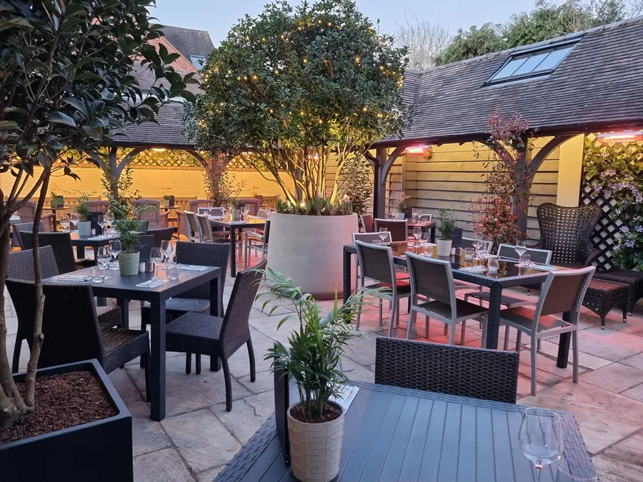 Tables beneath festoon-lit trees in the beer garden