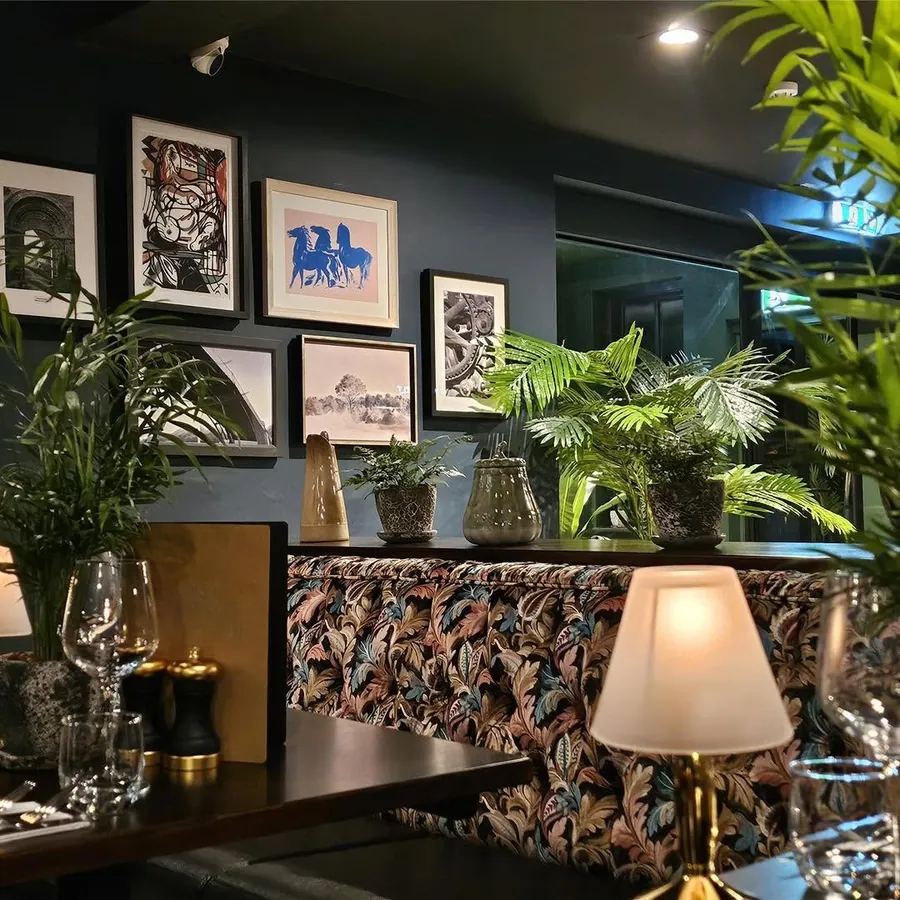 A gallery wall above a patterned banquette