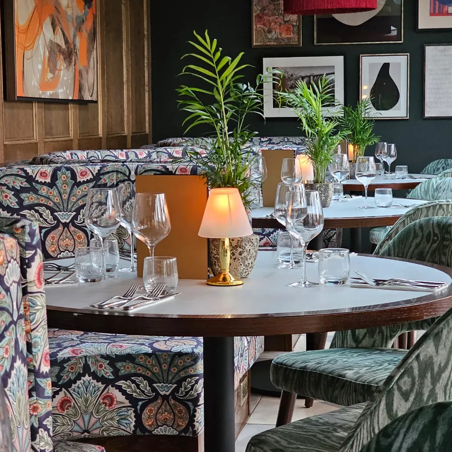 A booth table laid for dinner beneath the artwork