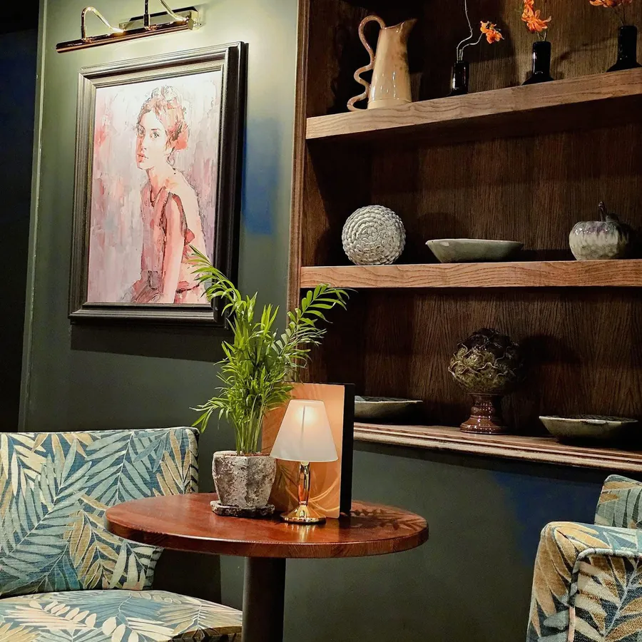 A portrait painting beside the oak shelves