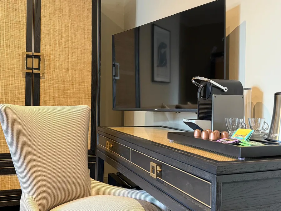 A bedroom desk with a Nespresso machine and flat-screen TV